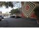 Open parking lot adjacent to a brick wall with a mural featuring concentric squares and a star at 377 King St # 203, Charleston, SC 29401