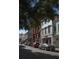 Street view with parked cars, mature trees, and a variety of shops and businesses at 377 King St # 203, Charleston, SC 29401