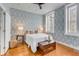 Bedroom with hardwood floors, windows with shutters, designer wallpaper, and a trunk at the foot of the bed at 40 State St # 1, Charleston, SC 29401