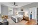Bedroom featuring a modern ceiling fan, a gray upholstered bed, and a view into the ensuite bathroom at 40 State St # 1, Charleston, SC 29401