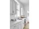 Bright kitchen features marble countertops, white cabinetry, stainless steel appliances, and tiled floors for style and function at 40 State St # 1, Charleston, SC 29401