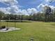 Expansive backyard featuring a serene pond, lush green lawn, and mature trees at 409 Spruce Ivy St, Moncks Corner, SC 29461