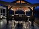 Night view of a covered outdoor kitchen with seating, lighting, and modern cooking appliances at 409 Spruce Ivy St, Moncks Corner, SC 29461