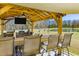 Impressive outdoor kitchen with bar seating, grill, and picturesque view of the pond at 409 Spruce Ivy St, Moncks Corner, SC 29461