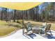 Inviting patio area with rocking chairs, a fire pit, and a shade sail, perfect for relaxing outdoors at 409 Spruce Ivy St, Moncks Corner, SC 29461