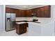 Well-equipped kitchen with stainless steel refrigerator, dark wood cabinets, and a bright countertop island at 416 Forest Hills Rd, Summerville, SC 29486