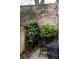 Landscaped backyard with lovely greenery and a brick wall, featuring a table and chairs at 42 1/2 Hasell St, Charleston, SC 29401