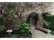 Brick-paved backyard showcasing lush greenery, a charming brick wall, and stone accents at 42 1/2 Hasell St, Charleston, SC 29401