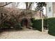 Private brick courtyard with gravel, greenery, and charming brick archway at 42 1/2 Hasell St, Charleston, SC 29401