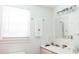 Bright white bathroom with window, decorative towel, modern vanity, and white ceramic sink at 42 1/2 Hasell St, Charleston, SC 29401