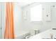 Bright white bathroom with peach shower curtain, decorative towels, toilet, and vanity with sink at 42 1/2 Hasell St, Charleston, SC 29401