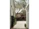 A tranquil courtyard featuring mature trees, a brick wall, and gravel, creating a serene outdoor space at 42 1/2 Hasell St, Charleston, SC 29401