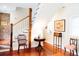 Bright foyer with beautiful hardwood floors, white staircase, and exposed brick detail at 42 1/2 Hasell St, Charleston, SC 29401
