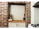 Rustic kitchen featuring exposed brick, white cabinets, and unique wooden countertop at 42 1/2 Hasell St, Charleston, SC 29401