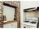 Charming kitchen featuring exposed brick, white appliances, and custom countertops at 42 1/2 Hasell St, Charleston, SC 29401