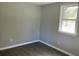 A simplistic bedroom with gray laminate flooring, neutral walls, and a bright window at 4230 S Rhett Ave, North Charleston, SC 29405
