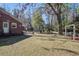 Side view of home and backyard featuring a brick exterior and mature trees, offering a private retreat at 425 Ravenwood Rd, Walterboro, SC 29488