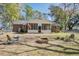 Charming backyard showcasing a screened-in porch, fire pit, and lush greenery for serene outdoor living at 425 Ravenwood Rd, Walterboro, SC 29488