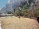 View of the backyard with garden beds, a metal fence, a firepit, and lots of surrounding trees at 530 Amalie Farms Dr, Charleston, SC 29492