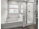 Bright bathroom with a soaking tub under a window and a glass-enclosed shower with marble tile at 530 Amalie Farms Dr, Charleston, SC 29492