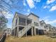 Back exterior of home with covered porch, deck, and stair access to backyard at 530 Amalie Farms Dr, Charleston, SC 29492