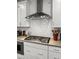 Close-up of range and hood in updated kitchen with white subway tiles at 530 Amalie Farms Dr, Charleston, SC 29492
