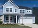 Charming two-story home with light-blue siding, covered front porch, attached garage, and well-maintained lawn at 562 Richfield Way, Summerville, SC 29486