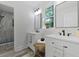 Bright bathroom featuring double vanity, a decorative mirror, and a tiled shower at 5806 Beverly Dr, Hanahan, SC 29410