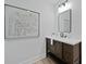 Chic bathroom with wood vanity, white countertop, black hardware, modern art, and decorative mirror at 5806 Beverly Dr, Hanahan, SC 29410