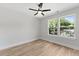 A bright bedroom features wood-look floors, a ceiling fan, and a view of the yard through the double windows at 5806 Beverly Dr, Hanahan, SC 29410
