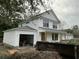 View of the home showing white siding and an attached garage and front porch at 5806 Beverly Dr, Hanahan, SC 29410