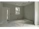 Unfinished room featuring a bright window, smooth concrete flooring, and a door, ready for customization at 5806 Beverly Dr, Hanahan, SC 29410