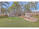 Serene backyard featuring lush lawn, mature trees, waterfront access and an outdoor seating area at 634 Lakeside Dr, Moncks Corner, SC 29461