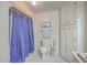 Full bathroom featuring shower with purple curtain, toilet, and storage cabinet at 634 Lakeside Dr, Moncks Corner, SC 29461