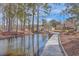 Scenic waterfront featuring a wooden dock, mature trees and landscaping for outdoor water enjoyment at 634 Lakeside Dr, Moncks Corner, SC 29461