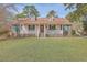Traditional home boasts a lovely front porch, green shutters, and a manicured front lawn at 634 Lakeside Dr, Moncks Corner, SC 29461
