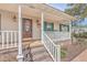 Inviting front porch with brick steps, white railing, and charming accents on the front door at 634 Lakeside Dr, Moncks Corner, SC 29461