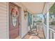 Charming front door with a wreath, rocking chairs, and a 'Lakeside Happenings' sign on the porch at 634 Lakeside Dr, Moncks Corner, SC 29461