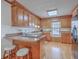 Well-lit kitchen boasts wood cabinetry, breakfast bar, window seat, and wood floors at 634 Lakeside Dr, Moncks Corner, SC 29461