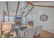 Open living room featuring a brick fireplace, wood beams, ceiling fan, and hardwood floors at 634 Lakeside Dr, Moncks Corner, SC 29461