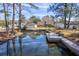 Panoramic waterfront view showing house, garage and long dock creating a serene living environment at 634 Lakeside Dr, Moncks Corner, SC 29461