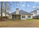 The back exterior shows a cozy screened porch and a well-maintained home with a spacious backyard at 8153 Governors Walk, North Charleston, SC 29418