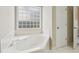 Bathroom featuring a soaking tub with a privacy window and a linen closet at 8153 Governors Walk, North Charleston, SC 29418