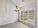 Dining room with a modern chandelier and big windows at 8153 Governors Walk, North Charleston, SC 29418