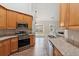 Well-lit kitchen featuring stainless steel appliances, granite counters, and wood cabinets at 8153 Governors Walk, North Charleston, SC 29418