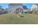 Spacious backyard with a screened porch, manicured lawn, and fire pit, ideal for outdoor entertainment at 100 Hunters Wood Dr, Summerville, SC 29485