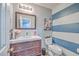 Stylish bathroom featuring a vanity with dark wood cabinets, a modern mirror, and striped accent wall at 100 Hunters Wood Dr, Summerville, SC 29485