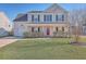 Charming two-story home featuring a well-maintained lawn, attached garage, and a welcoming red front door at 100 Hunters Wood Dr, Summerville, SC 29485