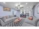 Open living area with gray couches and a view into the kitchen and breakfast bar at 100 Hunters Wood Dr, Summerville, SC 29485