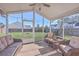 Relaxing screened porch with wicker furniture and string lights overlooking the landscaped backyard, perfect for outdoor living at 100 Hunters Wood Dr, Summerville, SC 29485